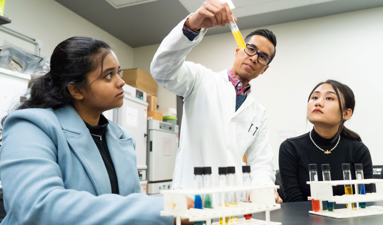 students and professor in lab