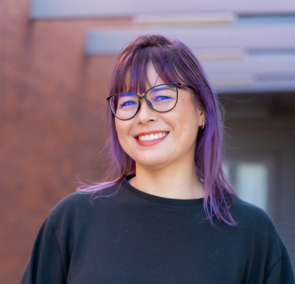 young woman with purple hair and glasses