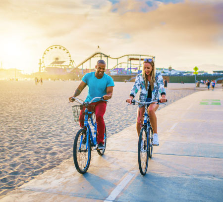 couple riding bikes near pier