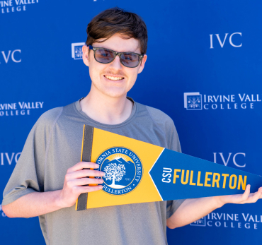 man holding CSU Fullerton pennant