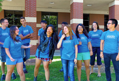 group of laughing students in matching shirts