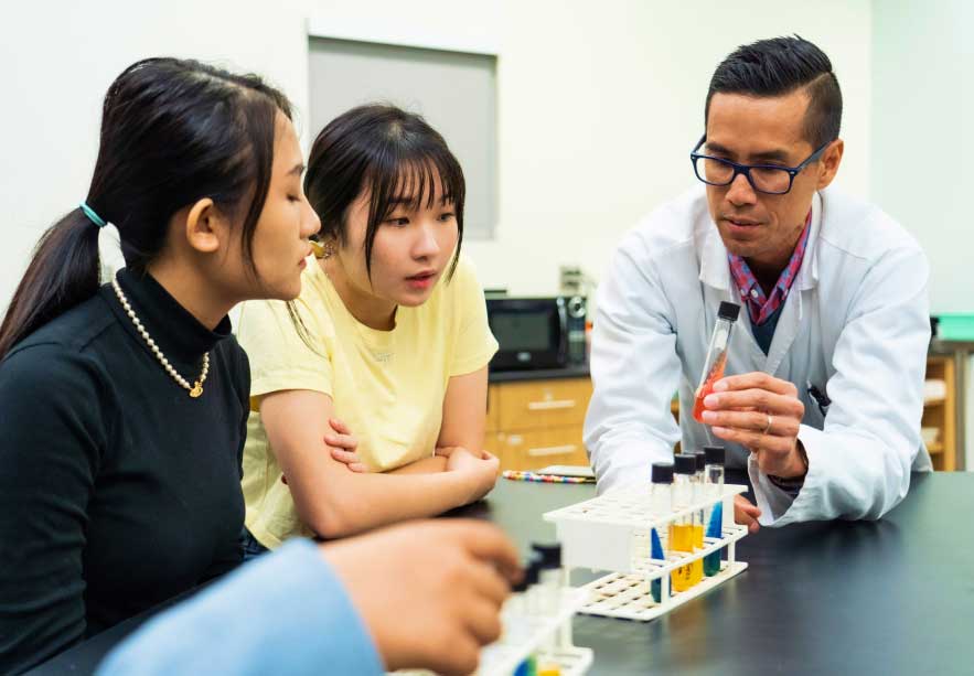 instructor and students in lab with vials